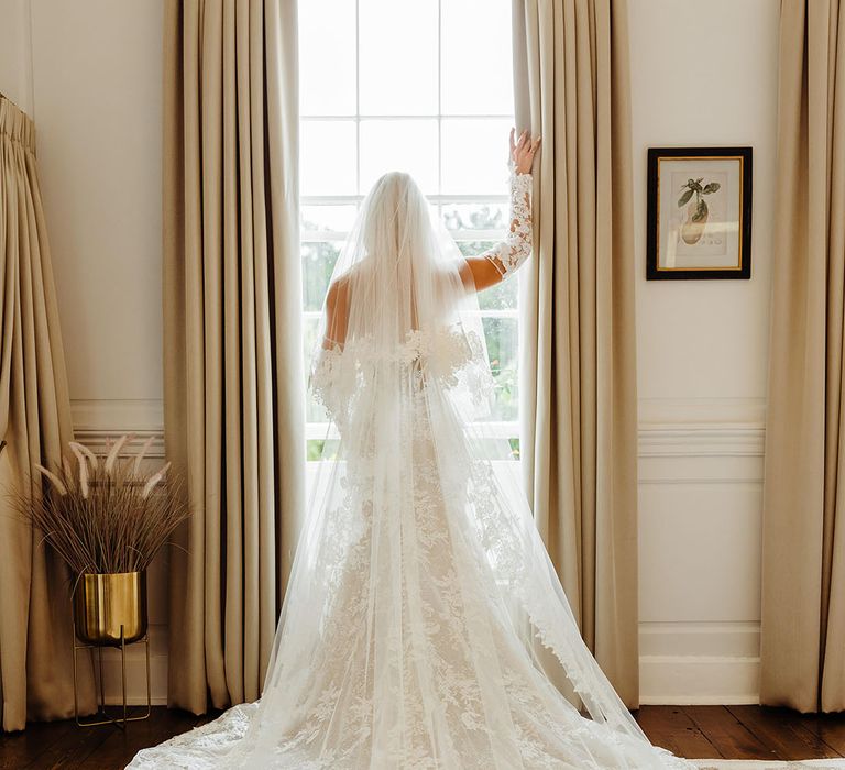 bride-wearing-embroidered-wedding-veil-with-lace-wedding-dress