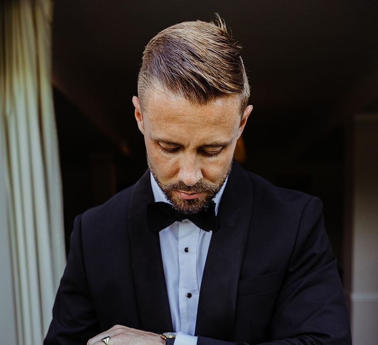 groom-buttons-up-cufflinks-with-black-tuxedo