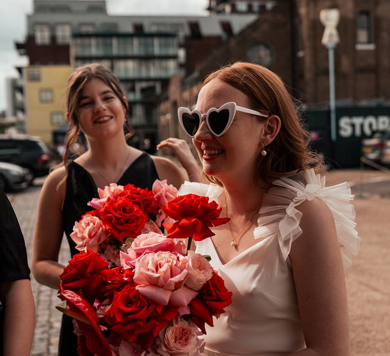 bride-in-ruffle-halfpenny-london-wedding-dress-with-white-sunglasses-and-cascading-bouquet.