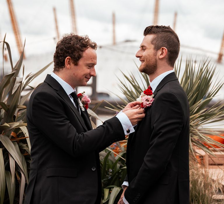 groom-gets-buttonhole-fixed-to-suit-jacket