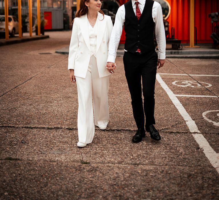 white-bridal-suit-reception-outfit-with-groom-in-black-suit