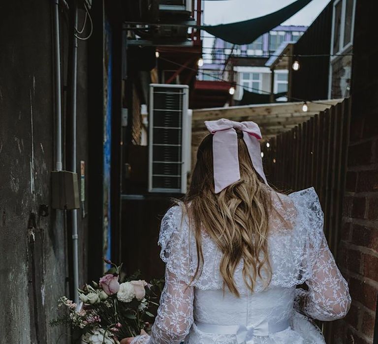 bride wearing long sleeve lace wedding dress from Oxfam