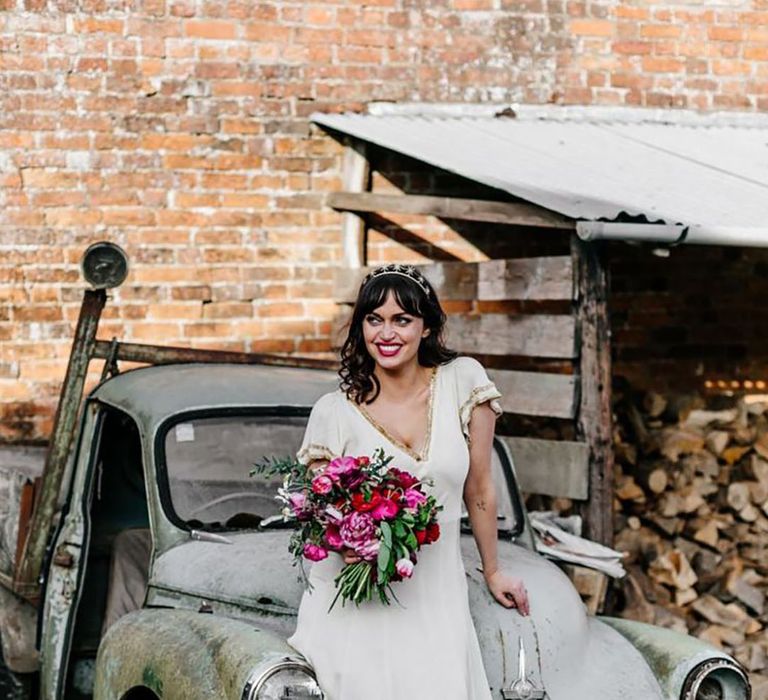 bride wearing off-white vintage wedding dress with gold trim