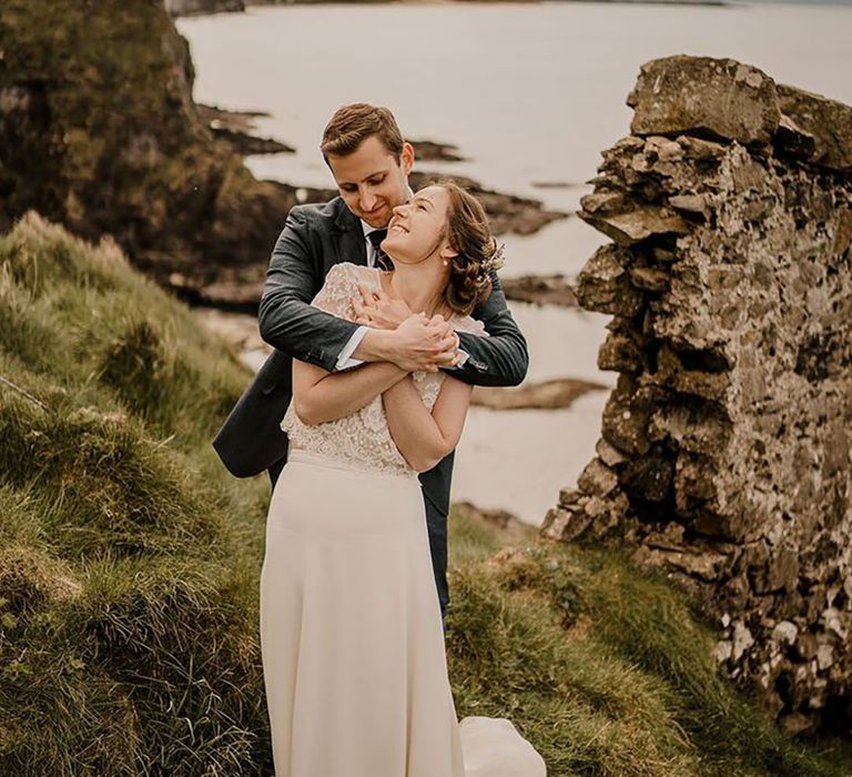 couple embracing by coastal cliffs for Irish wedding