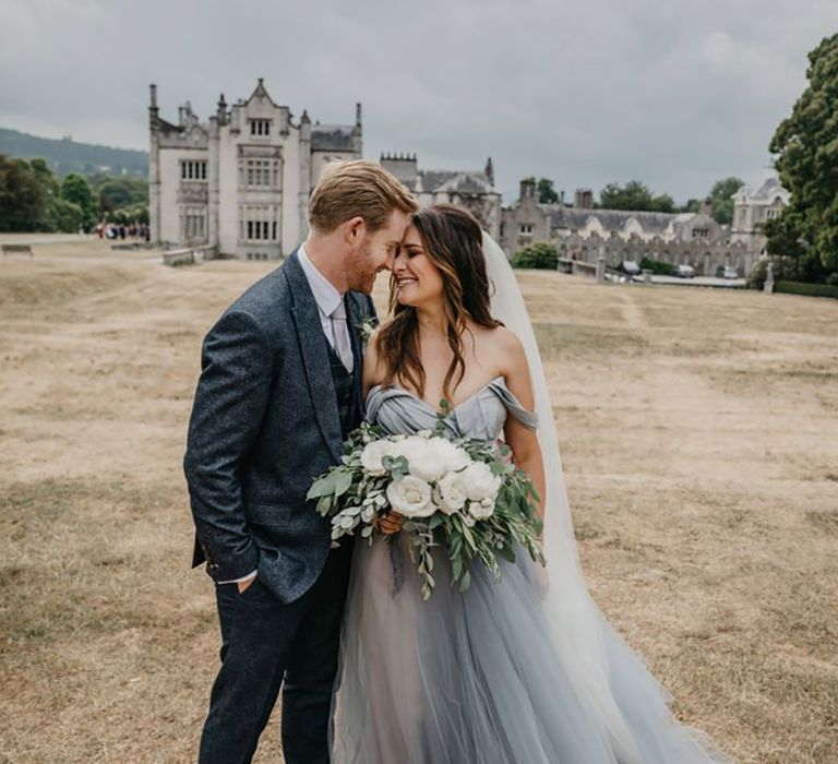 bride wearing blue wedding dress standing with groom at their summer wedding at Ireland venue