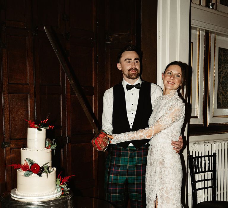 bride-and-groom-cut-three-tier-white-wedding-cake-with-sword