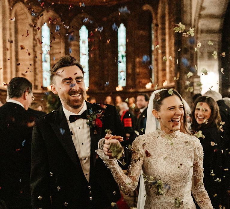 confetti-moment-at-wedding-day-with-bride-wearing-long-sleeve-lace-wedding-dress