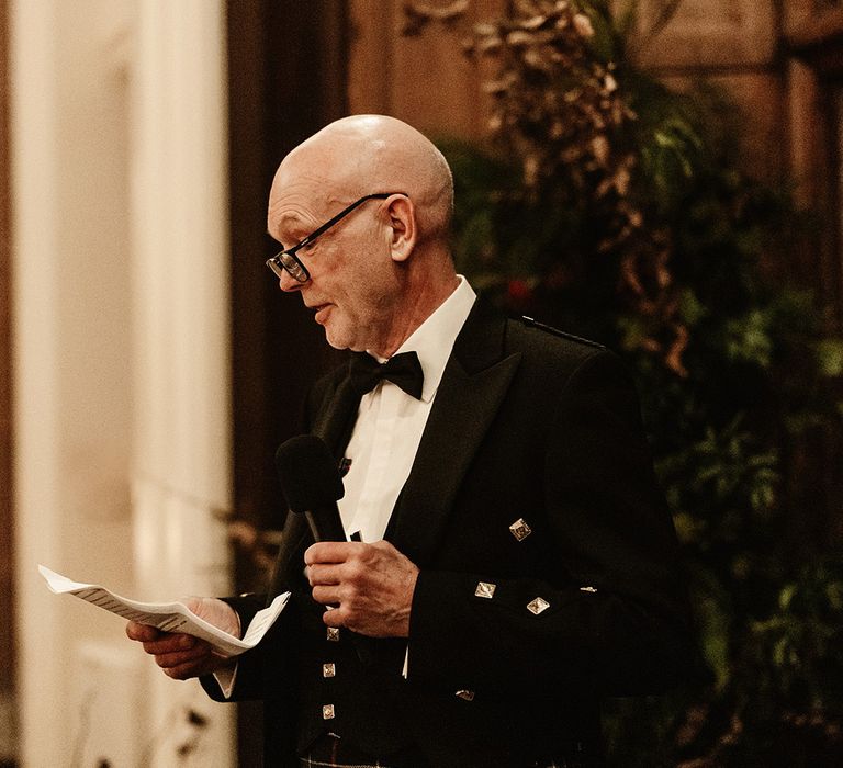 father-of-the-bride-wearing-kilt-reading-wedding-speech