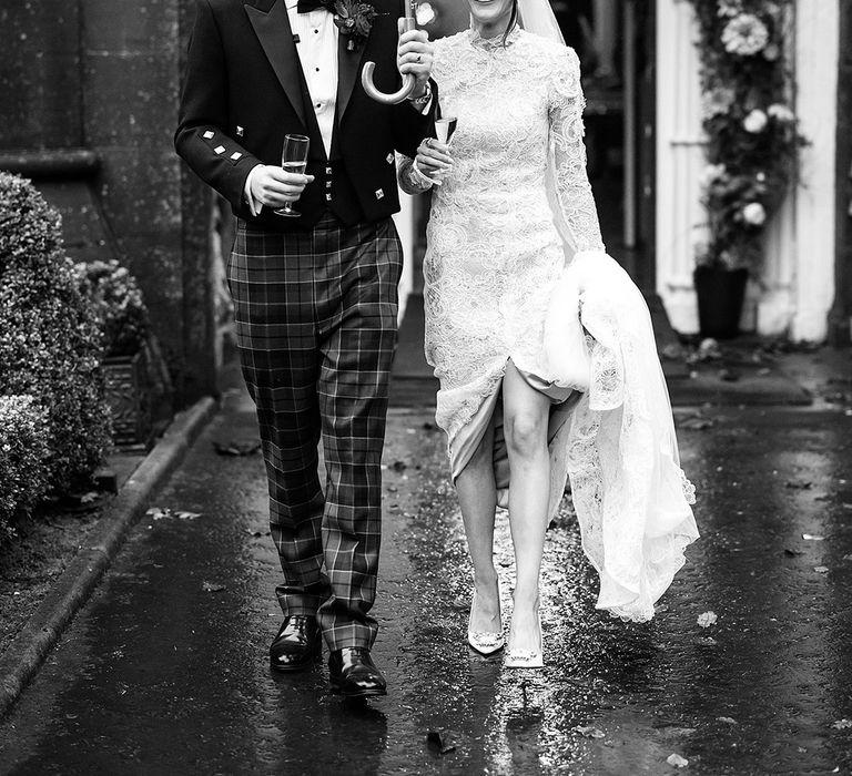 newylweds-walking-under-umbrella-at-rainy-winter-wedding