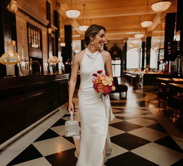 bride-carrying-sparkly-bridal-bag-with-pink-bouquet-in-satin-wedding-dress