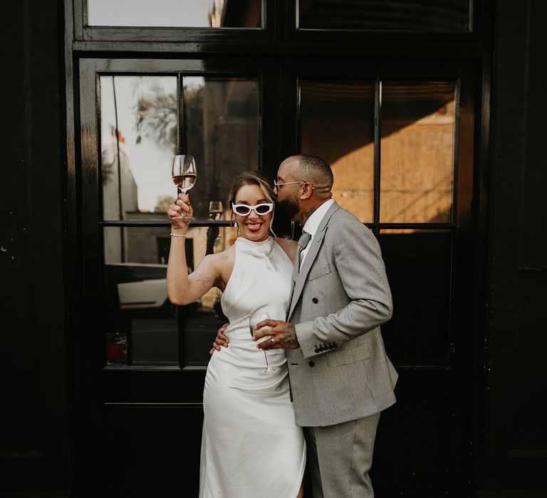 bride-in-halter-neck-satin-dress-with-groom-in-grey-suit-at-london-wedding