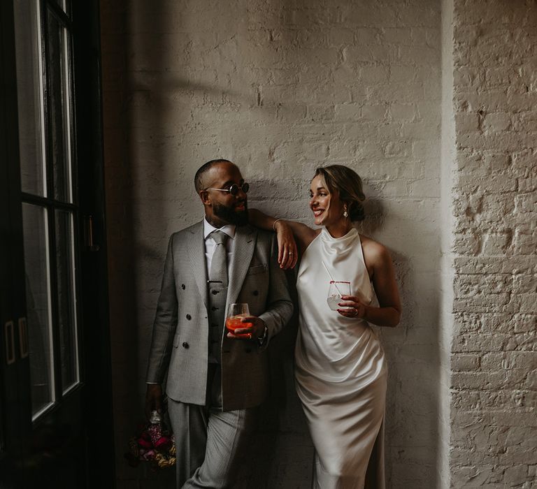 bride-in-minimalist-satin-slip-wedding-dress-with-groom-in-grey-suit