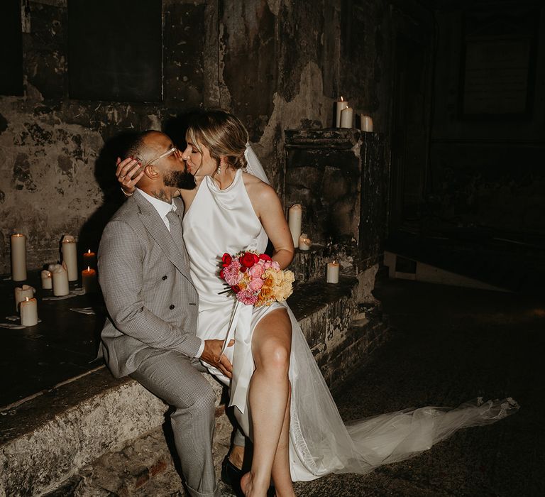 bride-wearing-halter-neck-satin-wedding-dress-with-pink-bouquet-with-grom-in-grey-suit