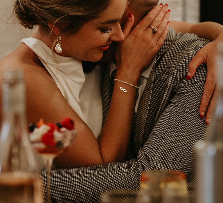 groom-embracing-bride-for-intimate-moment-at-wedding-breakfast