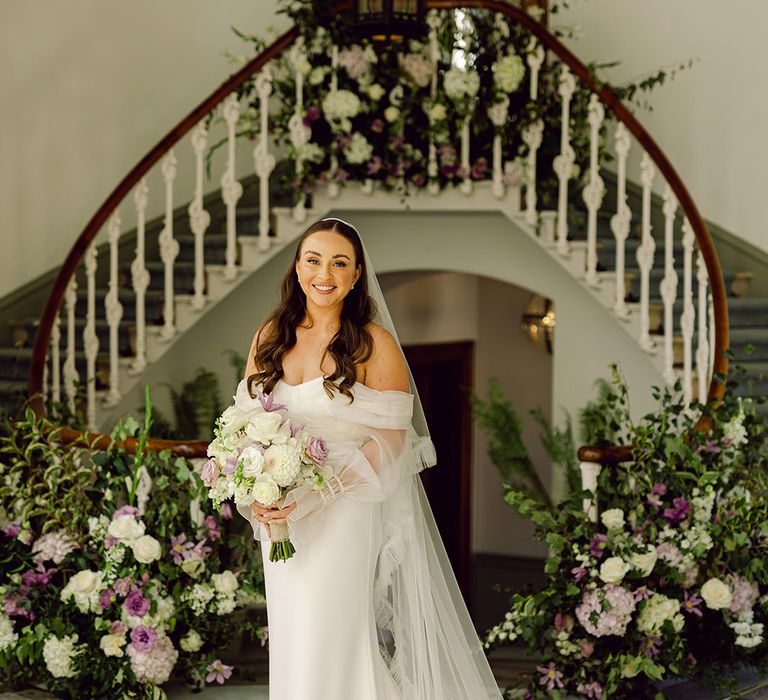 bride-wearing-custom-wedding-dress-with-lilac-bouquet