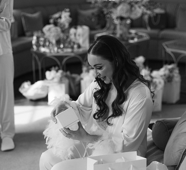 bride-wearing-feather-white-pyjamas-opening-gifts