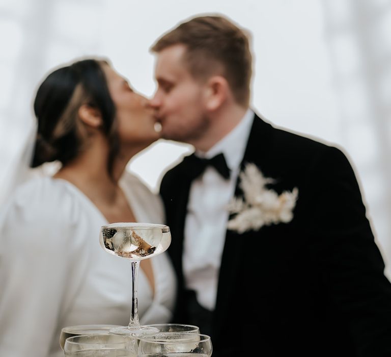 bride-and-groom-kiss-with-champagne-tower-decorations