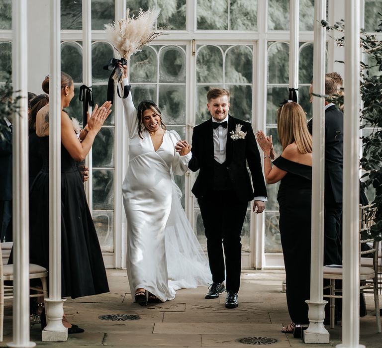 bride-and-groom-walking-back-down-the-aisle-as-a-married-couple