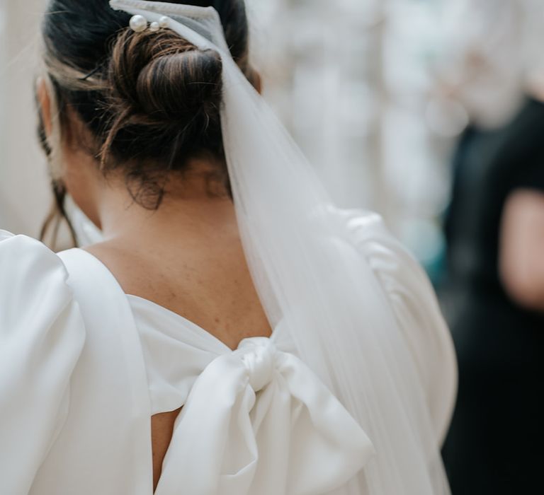 bride-wearing-bespoke-satin-bow-wedding-dress-and-veil