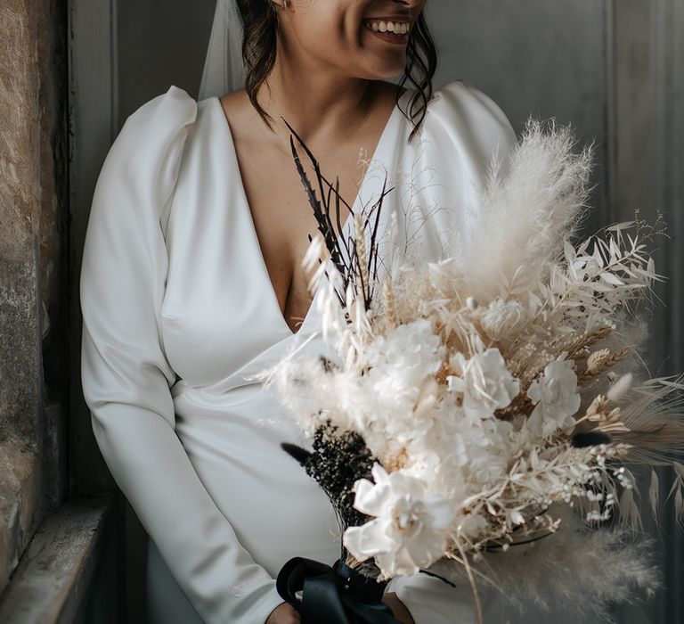 bride-wearing-puff-sleeve-wedding-dress-with-dried-flower-bouquet