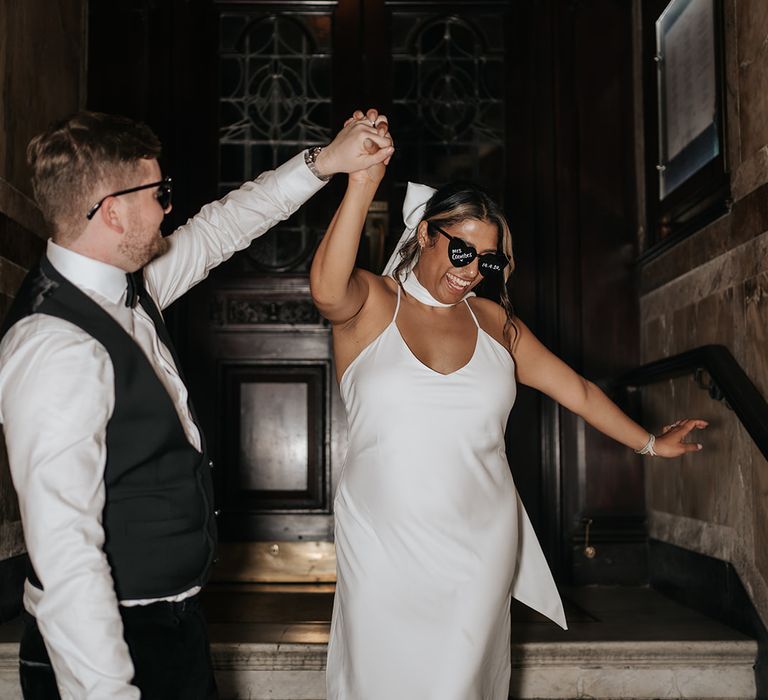 bride-wearing-satin-wedding-dress-with-hair-bow-and-sunglasses