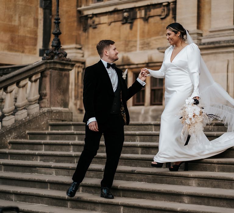 country-house-traditional-black-tie-wedding-with-bride-and-groom-walking-hand-in-hand