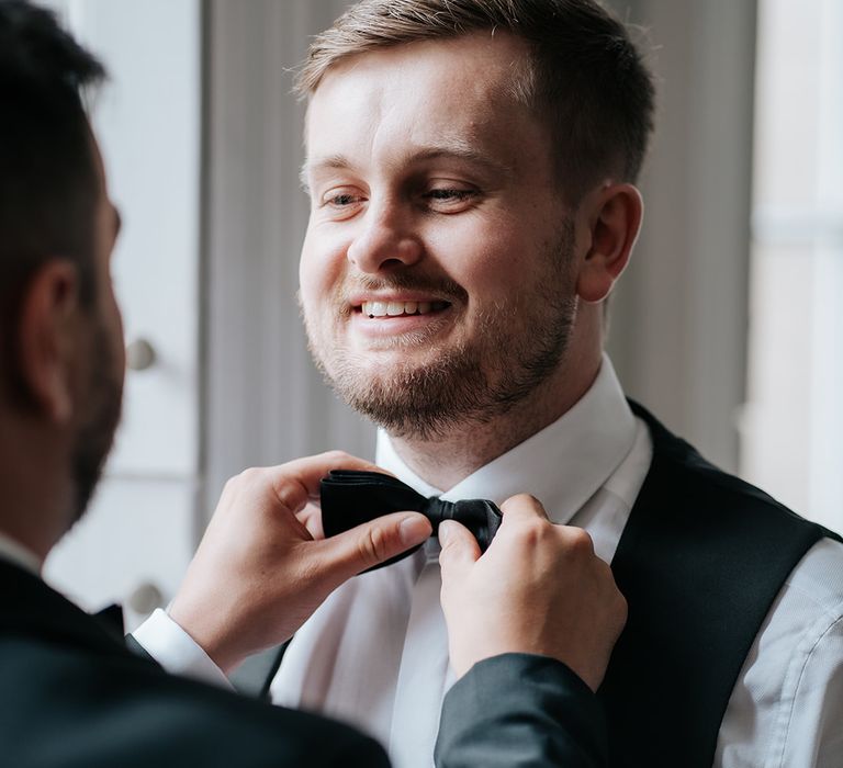 groom-getting-ready-for-wedding-with-bow-tie