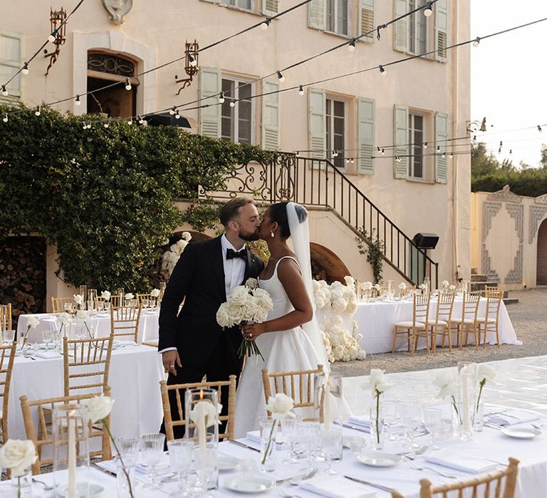 bride-and-groom-kiss-at-outdoor-wedding-breakfast