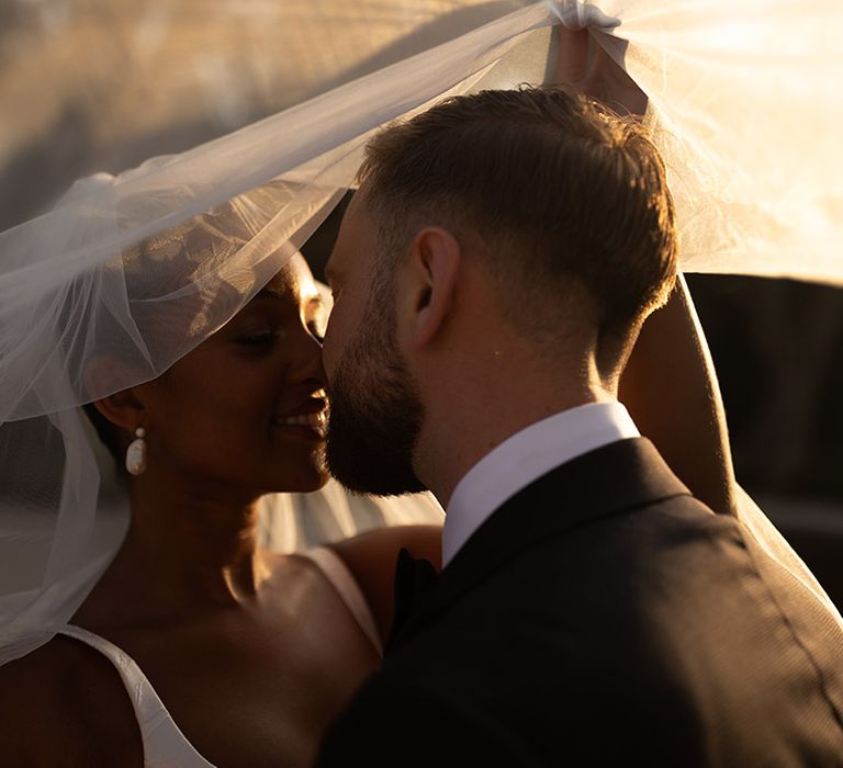 bride-and-groom-kiss-under-veil