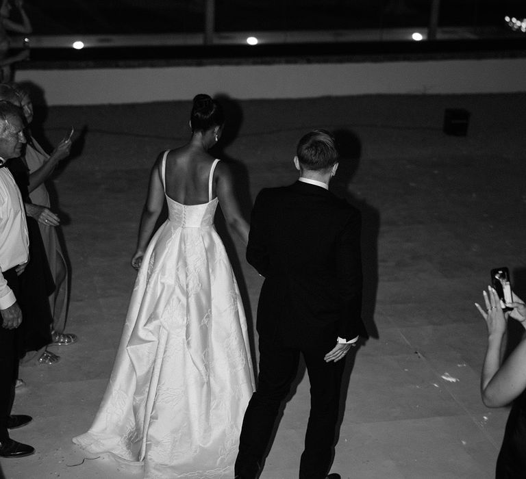 bride-and-groom-walk-hand-in-hand-at-wedding