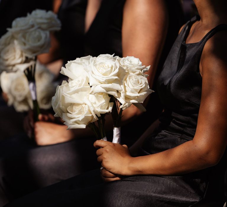 bridesmaids-in-black-satin-dresses-holding-white-rose-bouquet