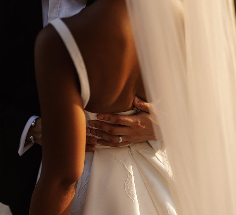 groom-embraces-bride-for-romantic-wedding-photo