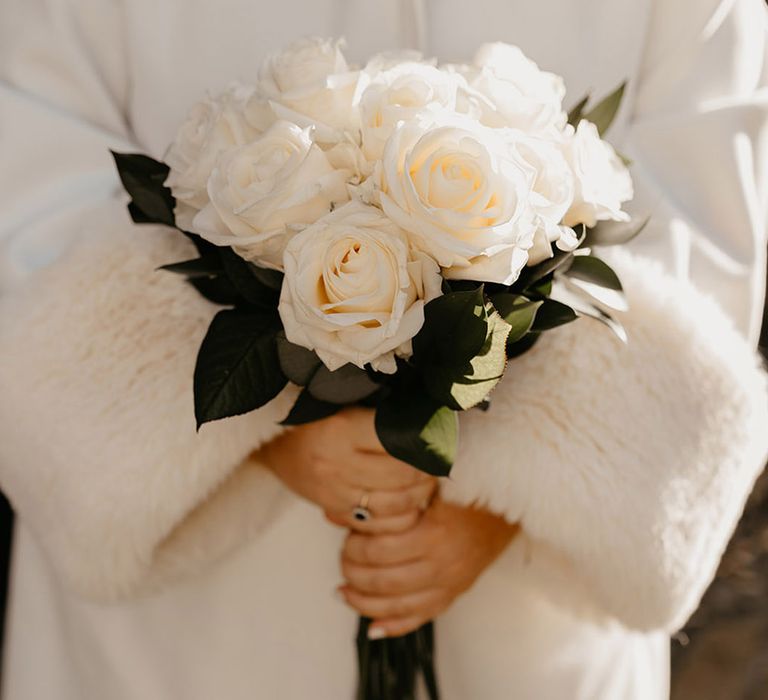 bride-holding-white-rose-wedding-bouquet