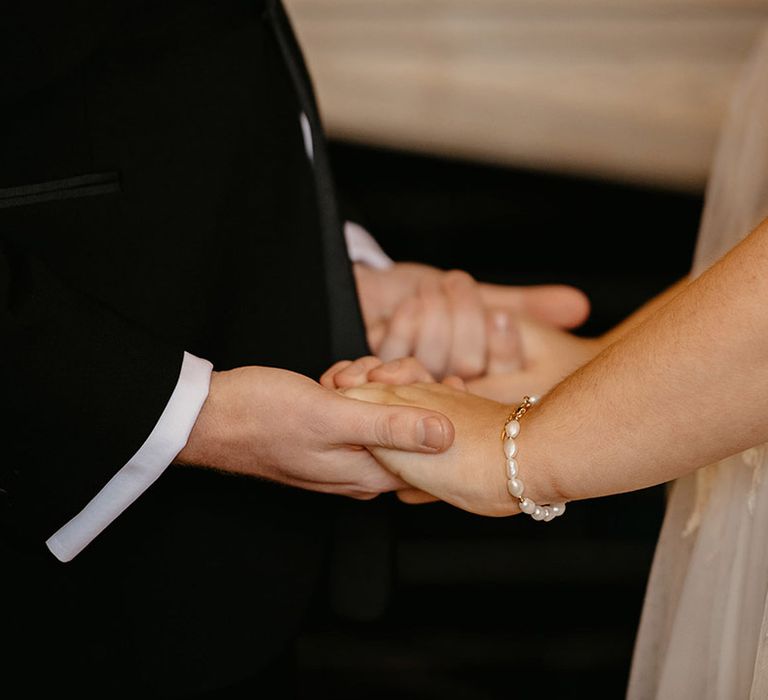 groom-holding-hands-with-bride-for-their-ceremony