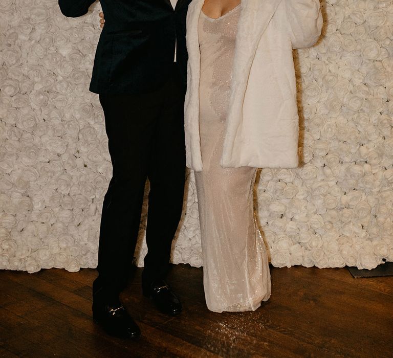 groom-in-black-tuxedo-with-bride-in-sparkly-reception-dress-with-neon-sign