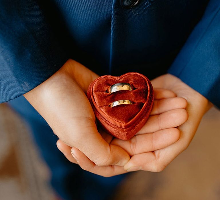 ring-bearer-holding-heart-shaped-ring-box-with-gold-wedding-bands