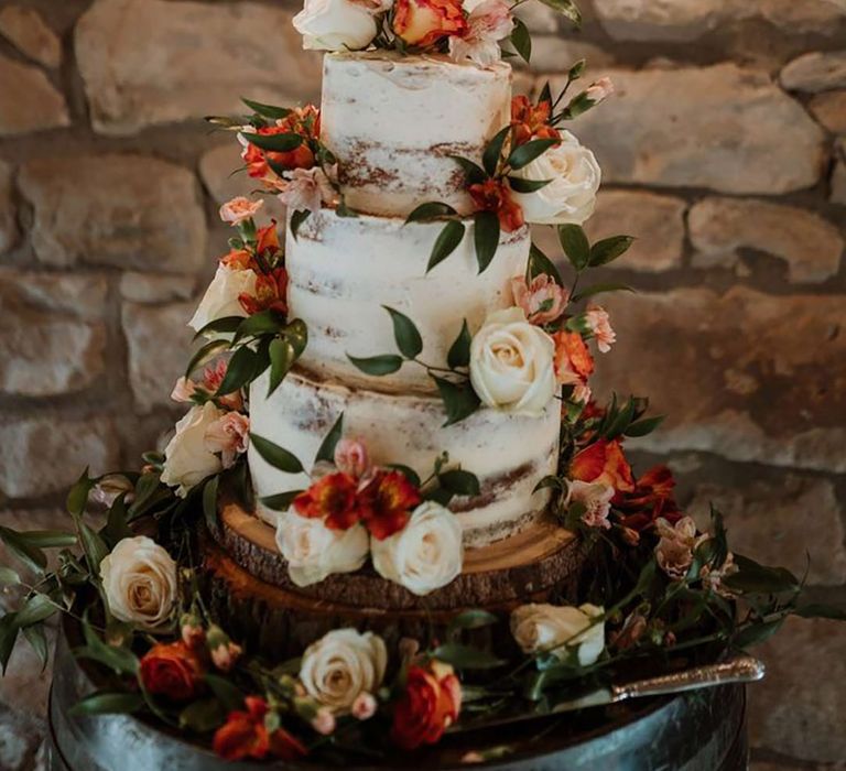 Three tiered wedding cake with buttercream, gold lasercut wedding cake topper and rose and foliage wedding cake decorations