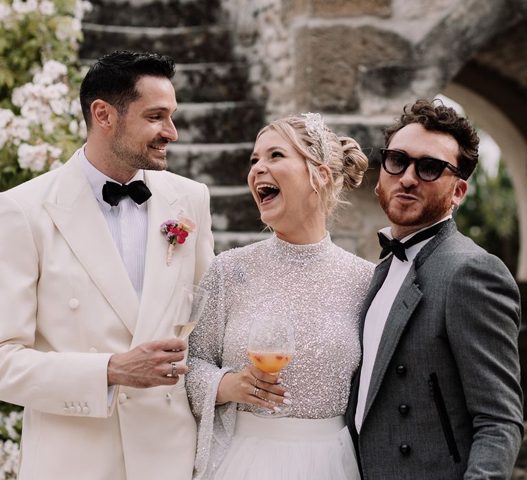 bride-and-groom-laughing-with-wedding-guest-with-cocktails