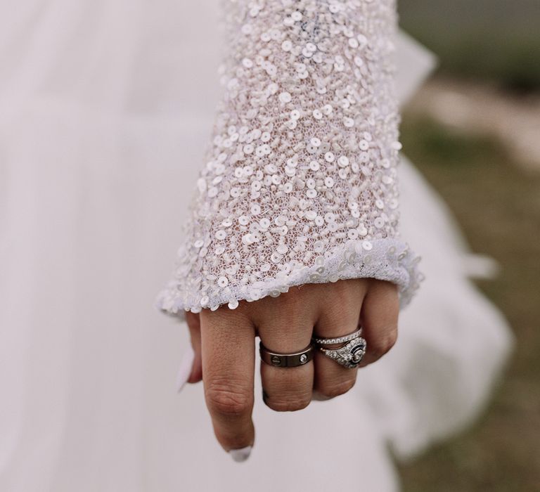 bride-wearing-long-sleeve-sequin-dress-with-diamond-rings-accessories