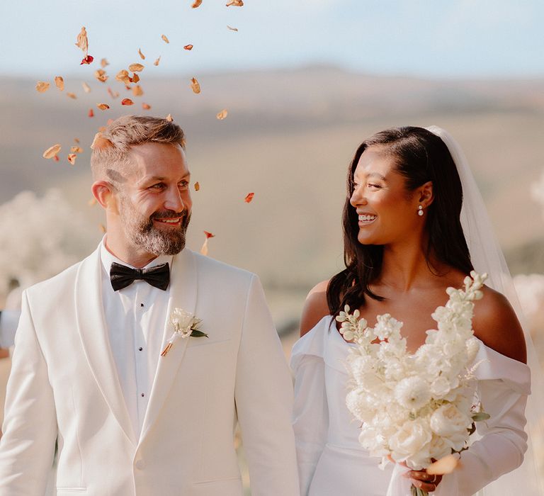 bride-and-groom-in-white-tuxedo-at-outdoor-wedding