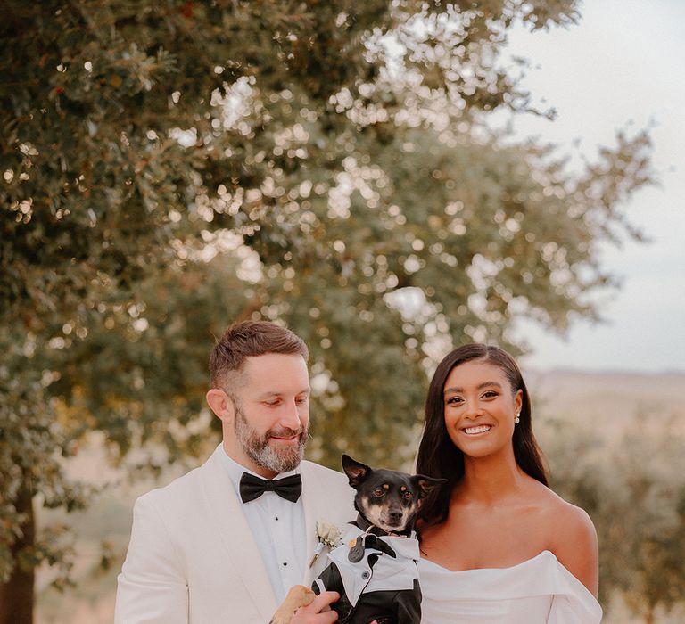 bride-in-off-the-shoulder-wedding-dress-with-groom-in-white-tuxedo.