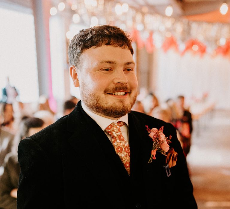 groom-wearing-flower-patterned-tie-with-dark-groom-suit