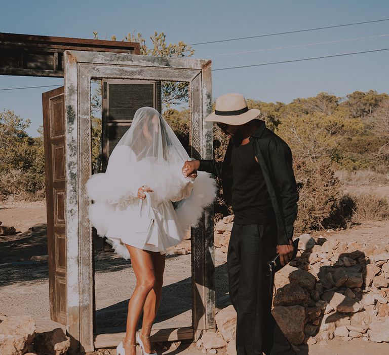 groom-in-dark-suit-with-hat-with-bride-in-short-wedding-dress-with-ruffle-veil