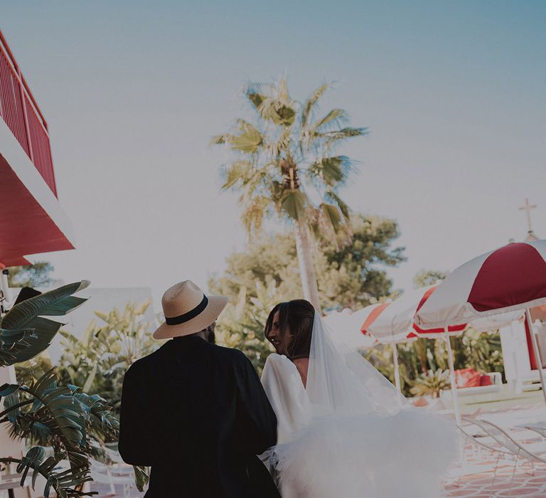 groom-walking-with-bride-in-short-wedding-dress-with-ruffle-veil