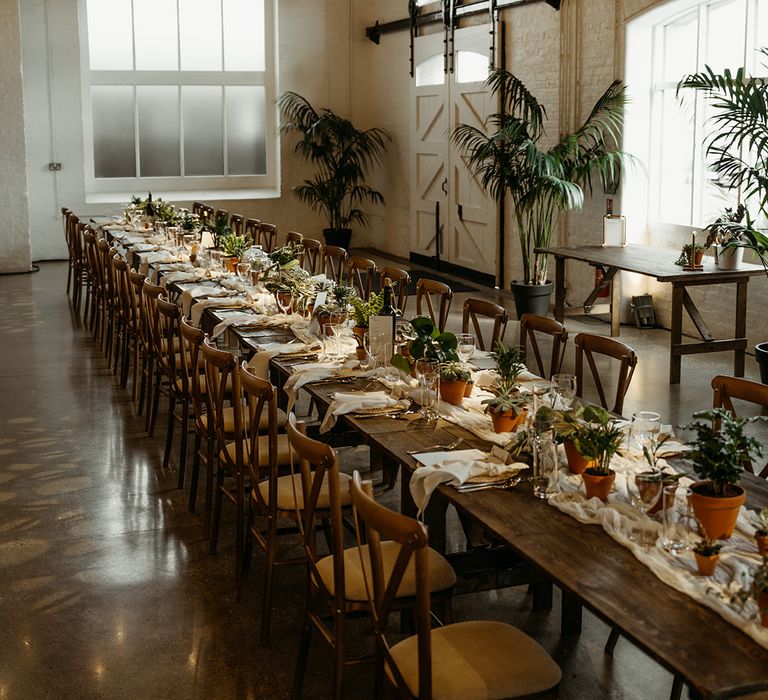 banquet-tables-decorated-with-house-plants-and-white-drapery