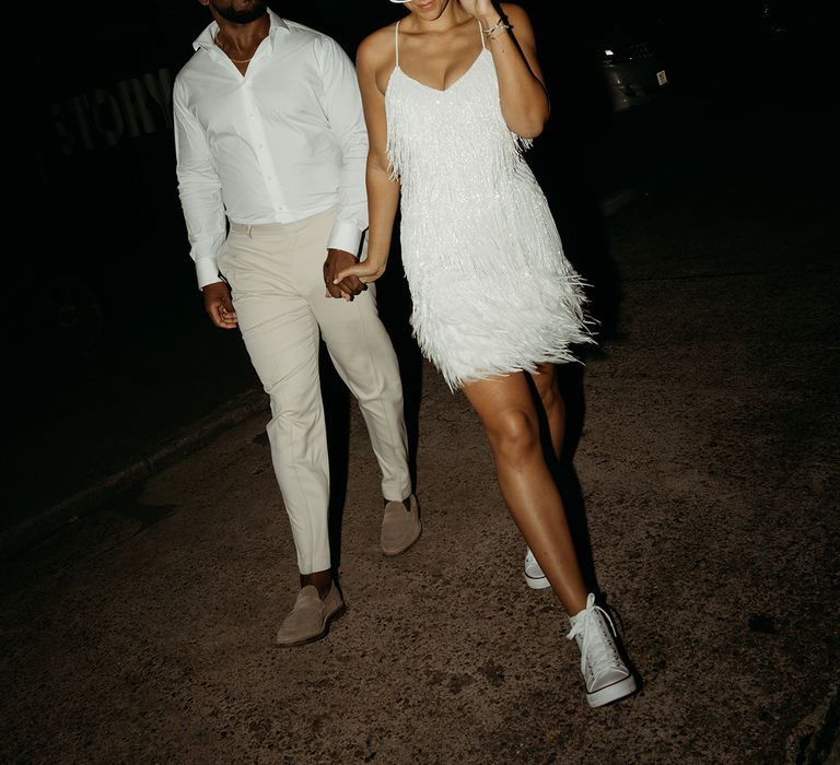 bride-in-white-tassel-wedding-dress-with-converses-walking-with-groom