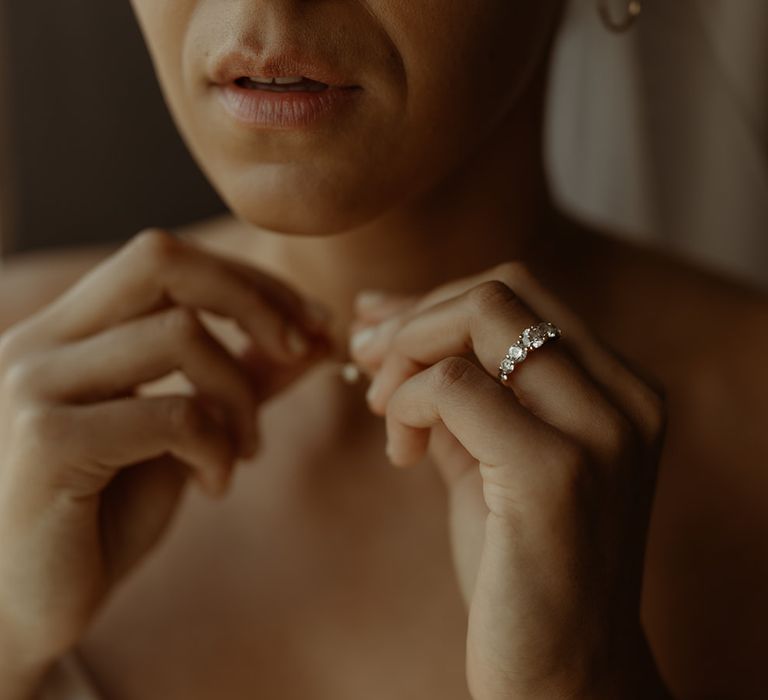 bride-putting-on-wedding-necklace-with-diamond-ring