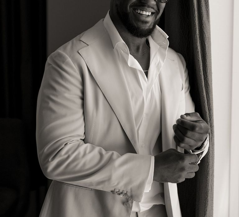 groom-wearing-sunglasses-and-cream-wedding-suit