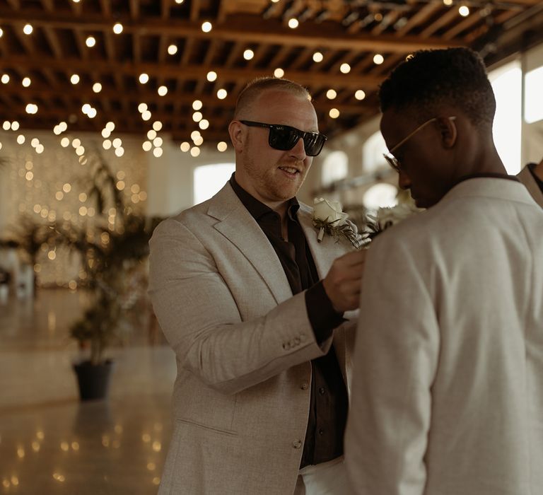 groomsmen-help-each-other-get-ready-for-wedding