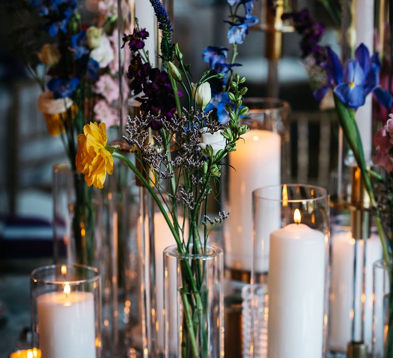 candles-in-hurricane-vases-with-blue-flowers